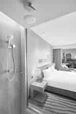 Camera con letto king size e vista panoramica sulla città dalla doccia