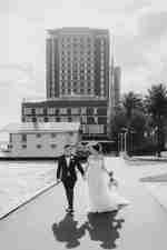 Sposa e sposo che camminano sul marciapiede ai margini del fiume Cigno.