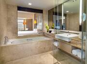 King Executive Suite Bathroom with Tub, Shower, Bathroom Amenities, and Window with View of Bedroom
