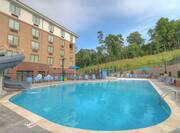 Daytime View of Water Slide, Leisure Seating, and Umbrellas at Outdoor Pool by Hotel Exterior