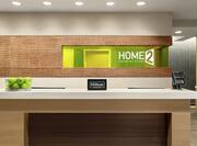 Welcoming front desk in lobby with Hilton Honors sign and green apples.