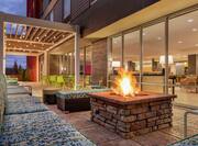Outdoor lounge area featuring comfortable sofa style seating, gazebo with string lights, and firepit.