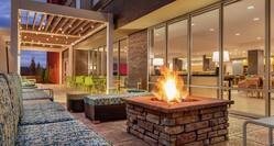 Outdoor lounge area featuring comfortable sofa style seating, gazebo with string lights, and firepit.