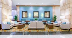 Illuminated Lamps, Soft Seating, Wood Tables, and Wall Mirrors in Lobby