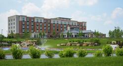 Daytime View of Hotel Exterior and Pond With Fountain