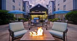 exterior patio with seating firepits and barbeques at dusk