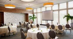 Meeting Room Set up with Round Tables and a Projection Screen
