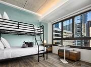 Bedroom With Bunk Beds And Outside View Of City Buildings