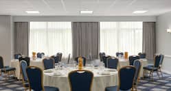 Spacious on-site ballroom featuring fully set banquet tables.