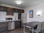Guest Suite Kitchen Area with Dining Table, Chairs, Refridgerator, Microwave and Dishwasher