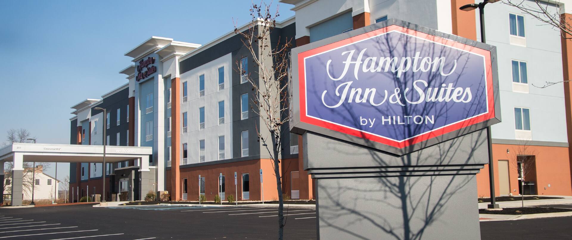 Hotel Building Exterior with Hampton Inn & Suites by Hilton Sign at Day