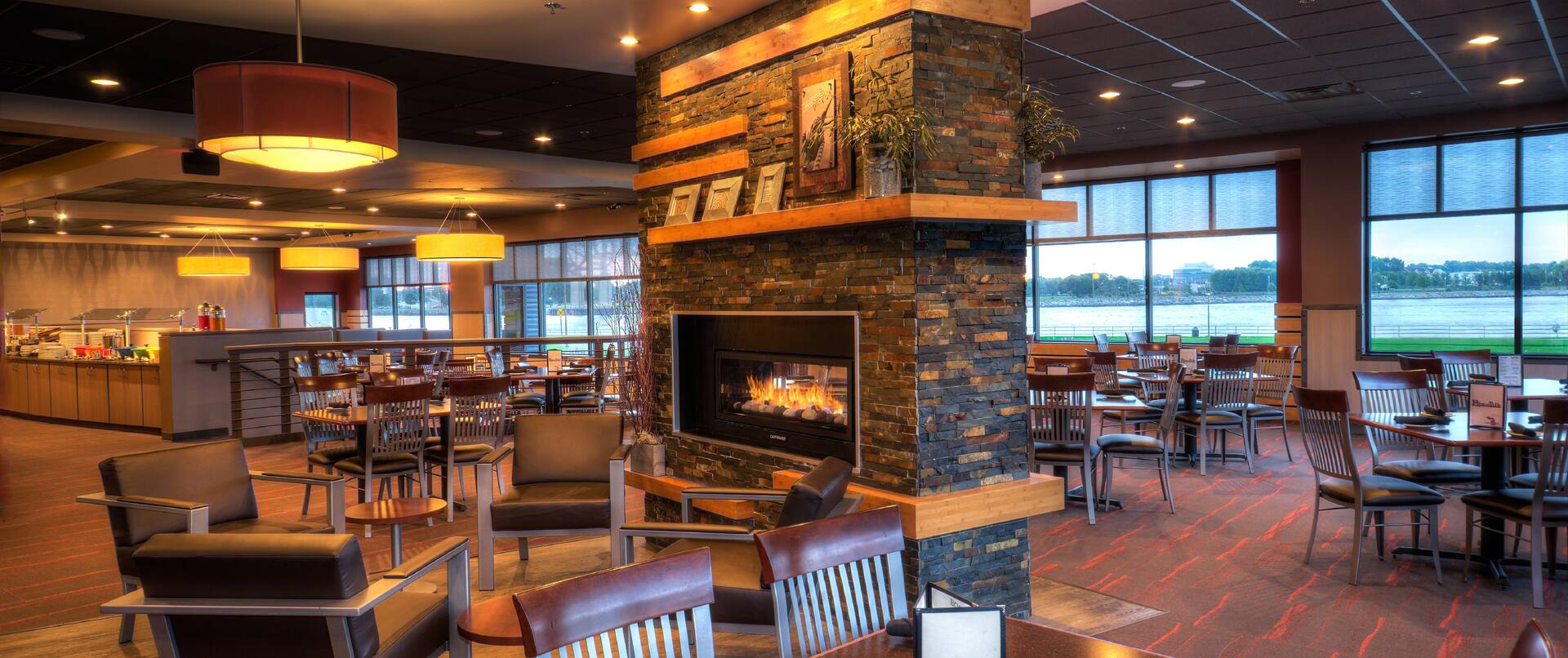 Dining Tables, Chairs, Wall Art, Fireplace, Windows, and Food Service Area in Restaurant