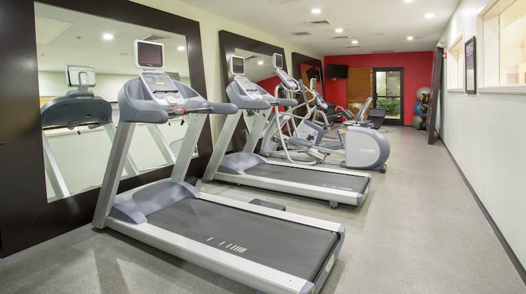 Fitness Center with Treadmills, Ellipticals, Mirrors, and Room Technology