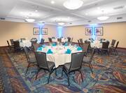 Social Dinner in Meeting Room with Four Large Round Tables with Eight Place settings and Blue Napkins