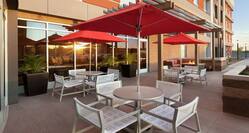 Outdoor patio featuring comfortable seating area, firepit, and patio tables with umbrellas.