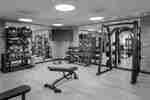 Fitness center with TV, benches and squat rack