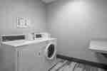 Guest Laundry Room With Coin Operated Washer, Dryer, and Folding Table