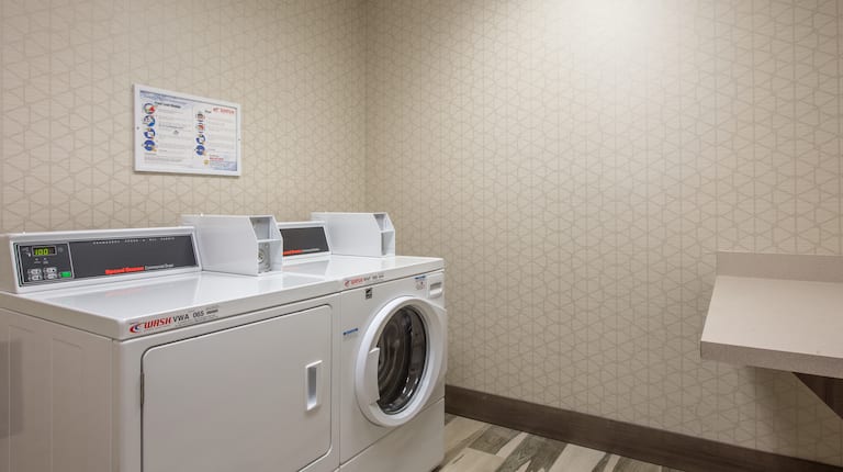 Guest Laundry Room With Coin Operated Washer, Dryer, and Folding Table