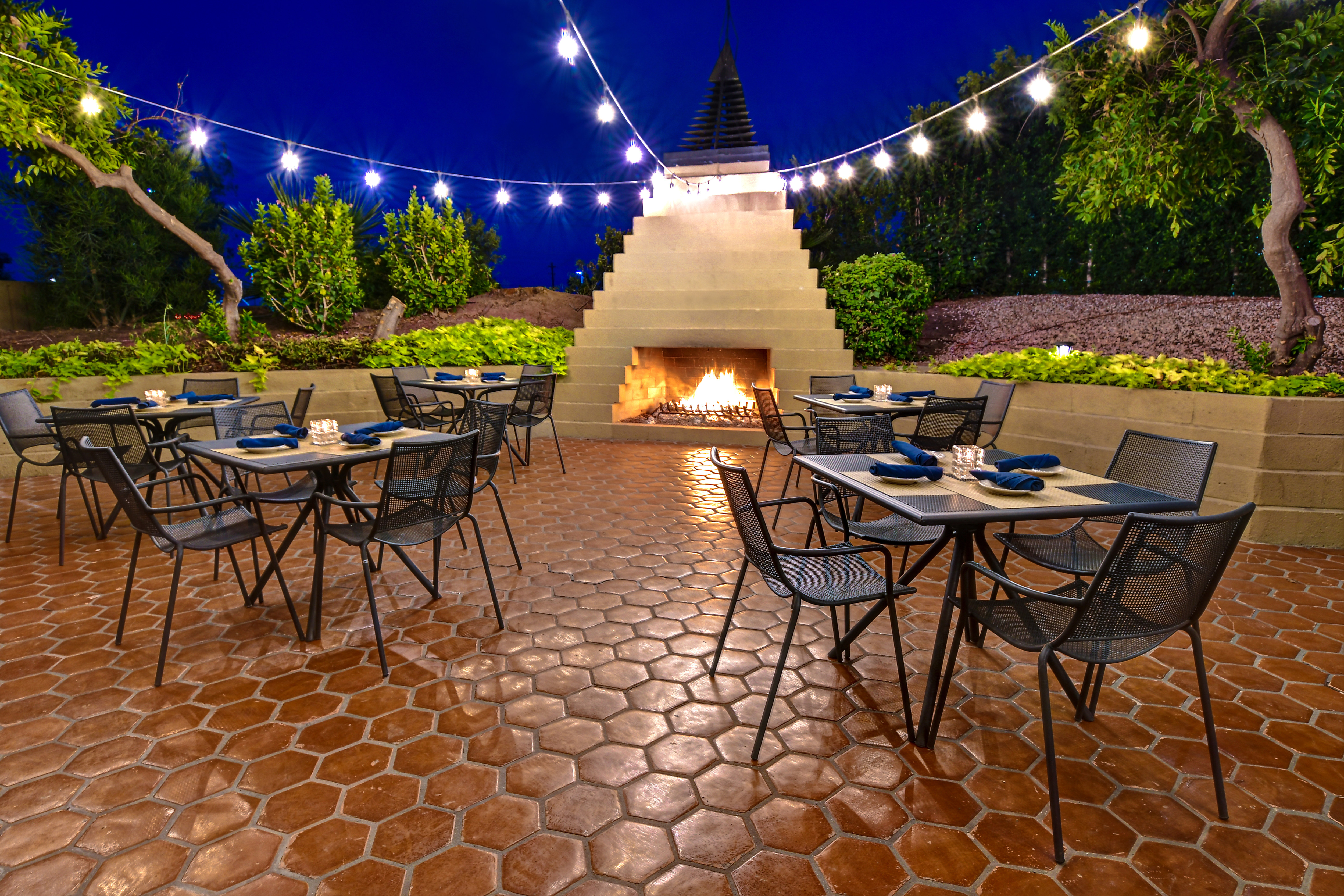 outdoor seating area with fireplace at dusk