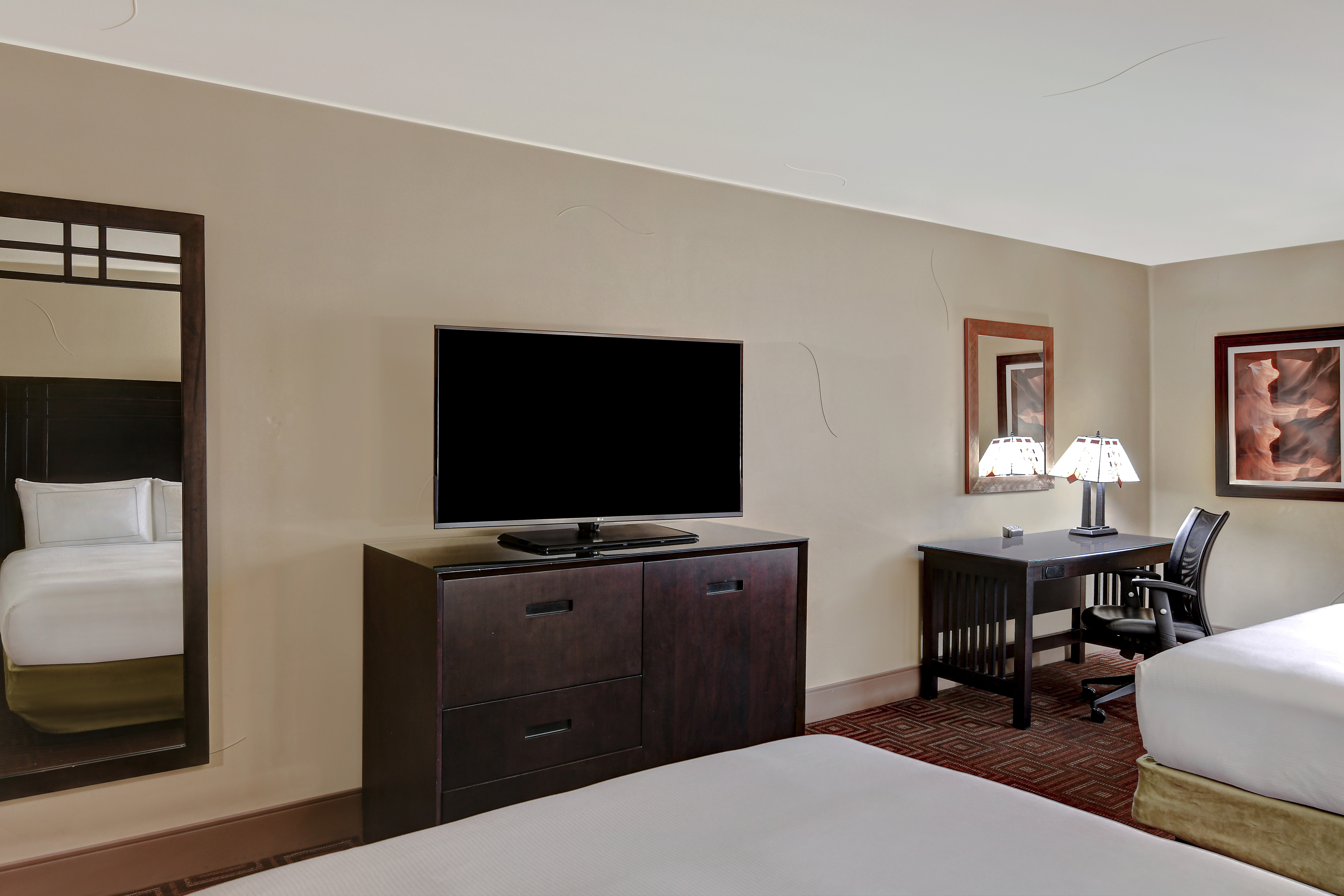 guest room with two beds television and work desk