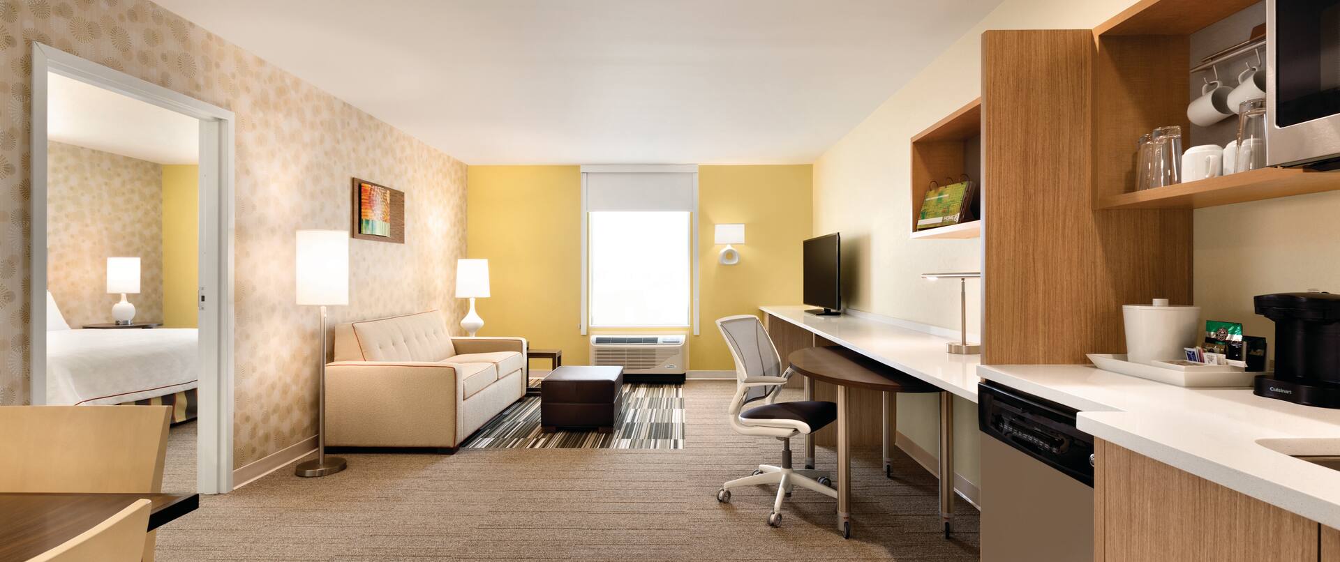 Suite Living Area with Kitchen, Work Desk, Lounge Seating, Television and Entry to Bedroom