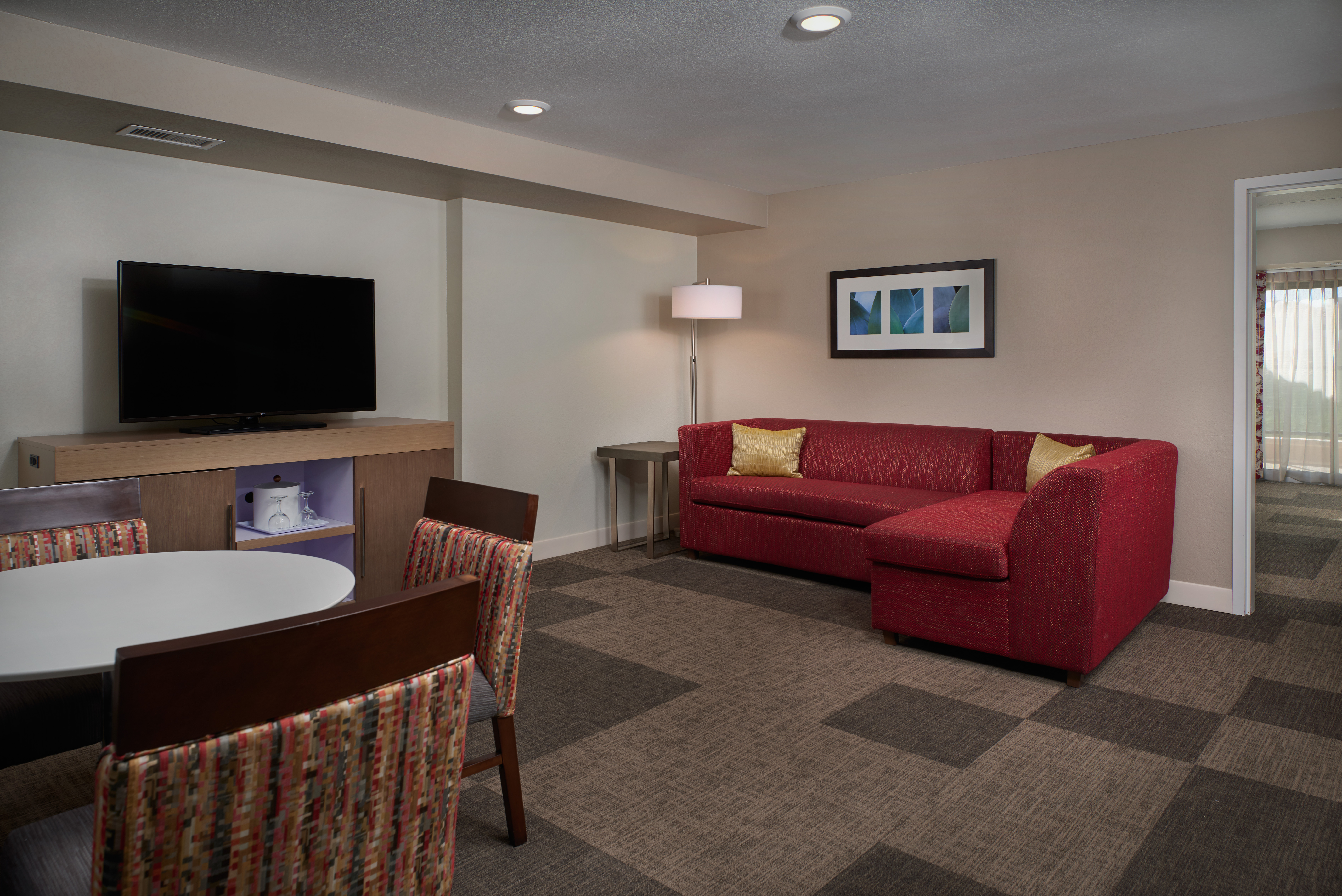 Guest Suite Lounge Area with Sofa, Chairs, Table and HDTV