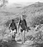 Young couple hiking outdoors on a trail at Phoenix Sonoran Preserve in Phoenix, Arizona.