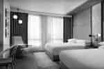 Zwei Betten im Zimmer mit Stuhl am Fenster
