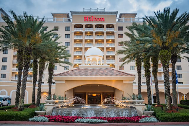 Hotel Exterior View with Water Fountain Palm Trees and Flowers