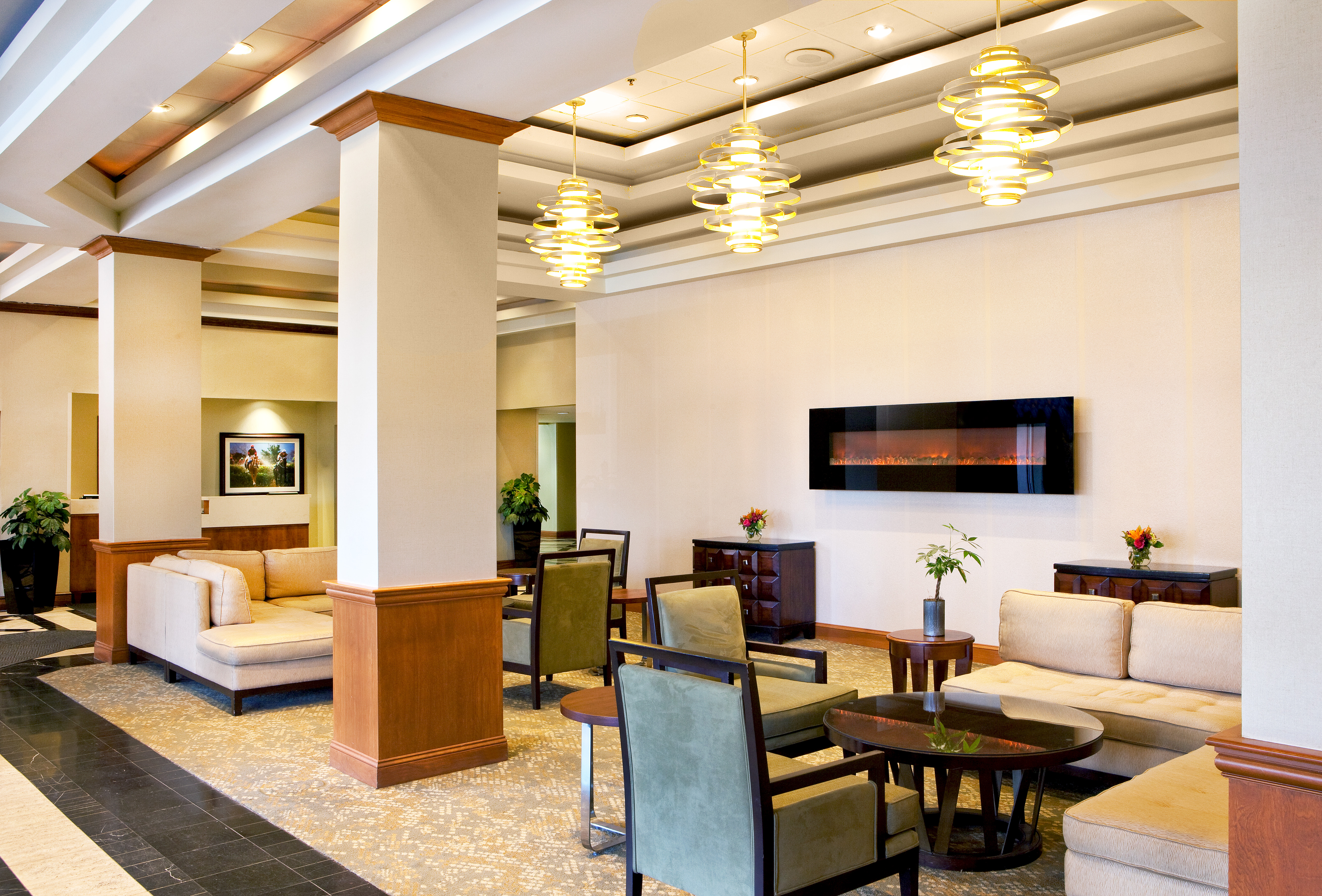Wall Art, Tables and Mixed Seating Around Fireplace in Lobby Lounge Area