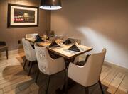 Private Dining Room in Bigelow Grille With Wall Art Between Two Armchairs, Seating and Place Settings for 6 at Table