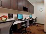 Business Center With Overhead Cabinets, Two Computer Workstations, Ergonomic Chairs, and Wall Clock