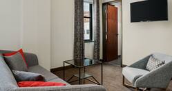 Guest Studio Suite with Sofa, Glass Coffee Table, Armchair and Wall Mounted HDTV