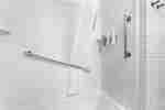 Ducha accesible para personas con discapacidades y bañera con barras de apoyo