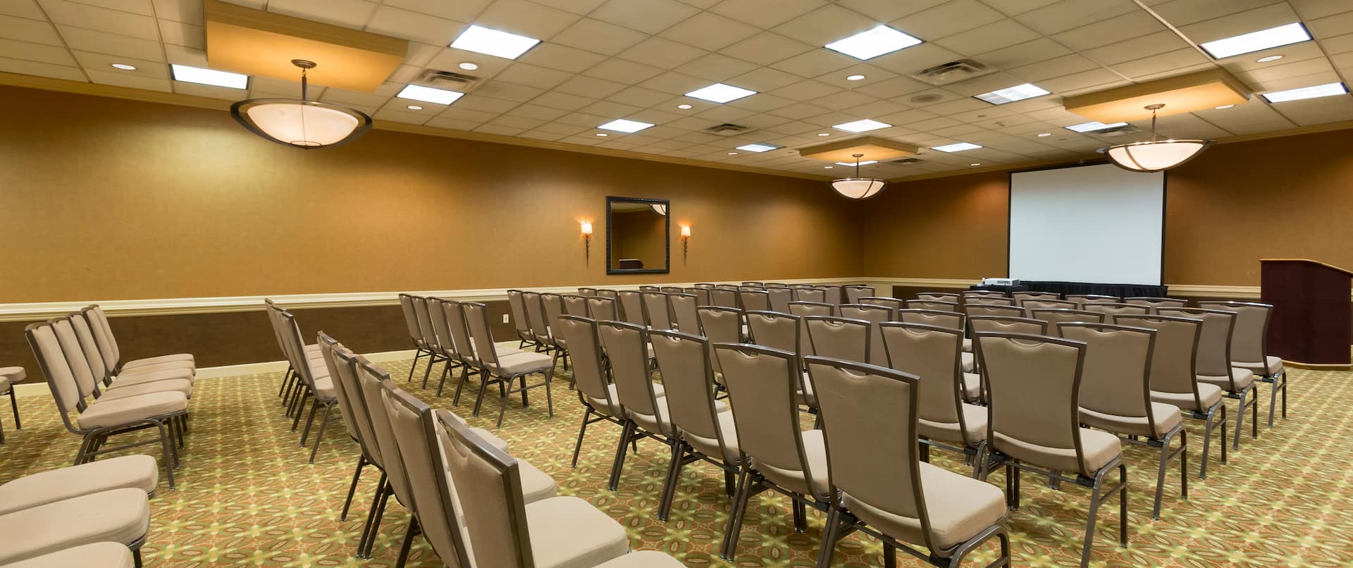 Meeting room with theater setup chairs facing projector screen