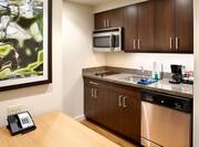 Suite kitchen with stove, sink, dish washer, microwave, coffee maker, and dining table