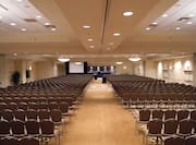 Grand Ballroom Arranged Theater Style With Rows of Chairs Facing Projector Screen and Stage