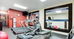 Fitness Center with Mirrored Wall and Cardio Machines