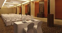 Vihara Meeting Room Arranged Theater Style With Rows of White Chairs Facing White Table With Two White Chairs and Podium