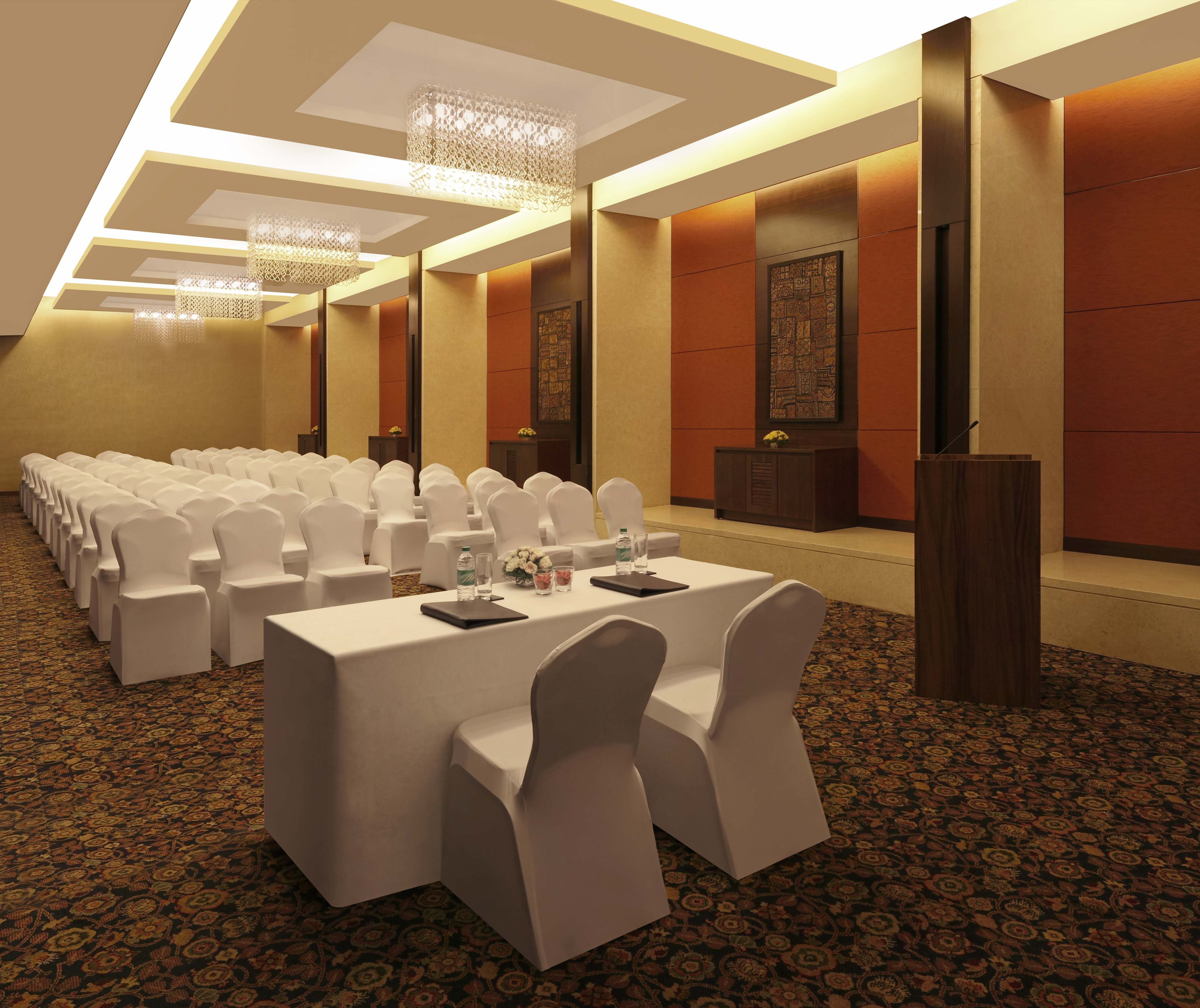 Vihara Meeting Room Arranged Theater Style With Rows of White Chairs Facing White Table With Two White Chairs and Podium