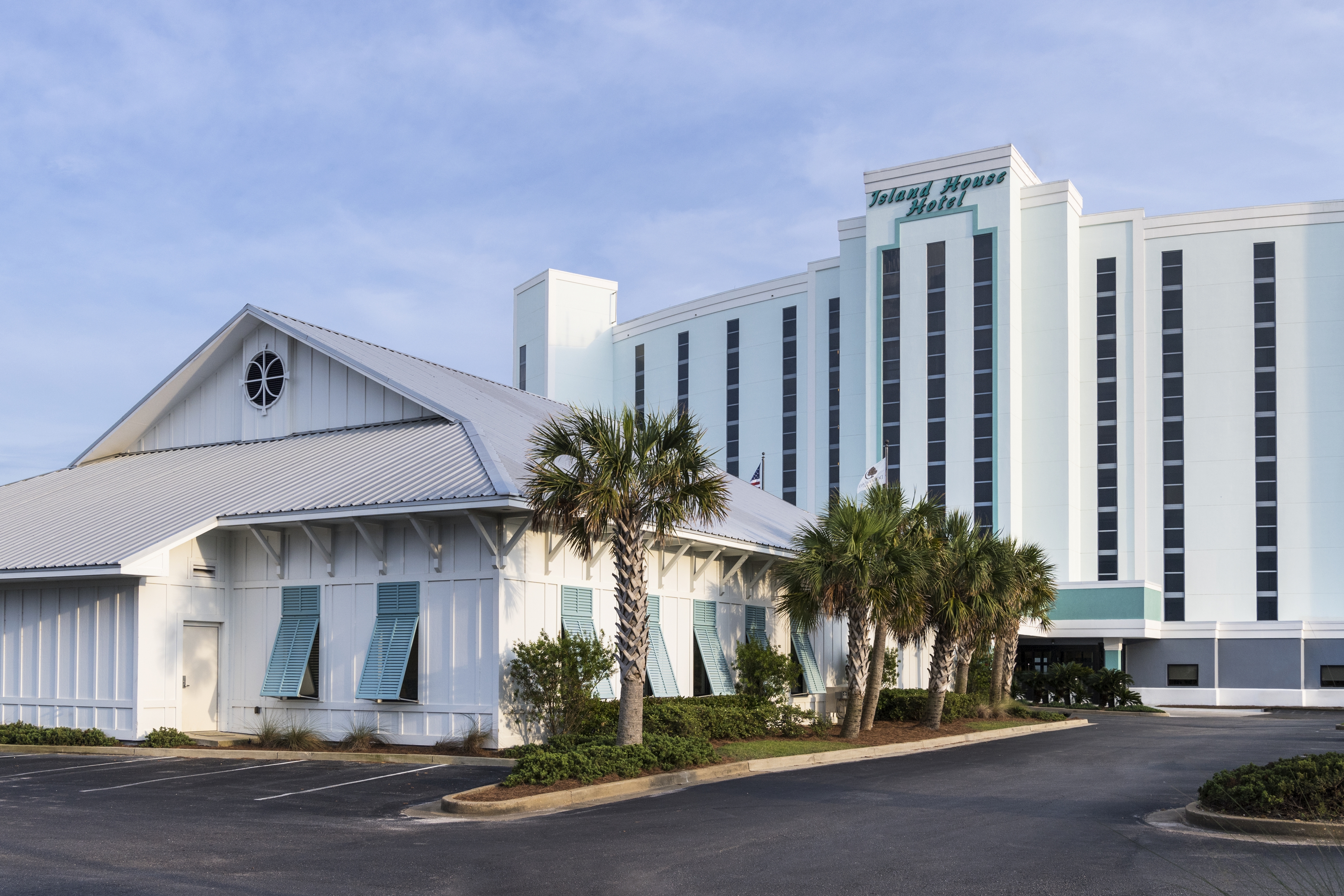 Daytime View of Ballroom Exterior Surrounded by Palm Trees and Hotel Exterior with Signage