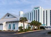 Daytime View of Ballroom Exterior Surrounded by Palm Trees and Hotel Exterior with Signage