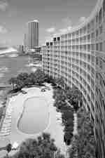 Vue de jour de l'extérieur de l'hôtel, piscine avec fauteuils, tables avec parasols et paysage