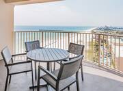 Junior suite balcony with lounge table, chairs, and gulf view