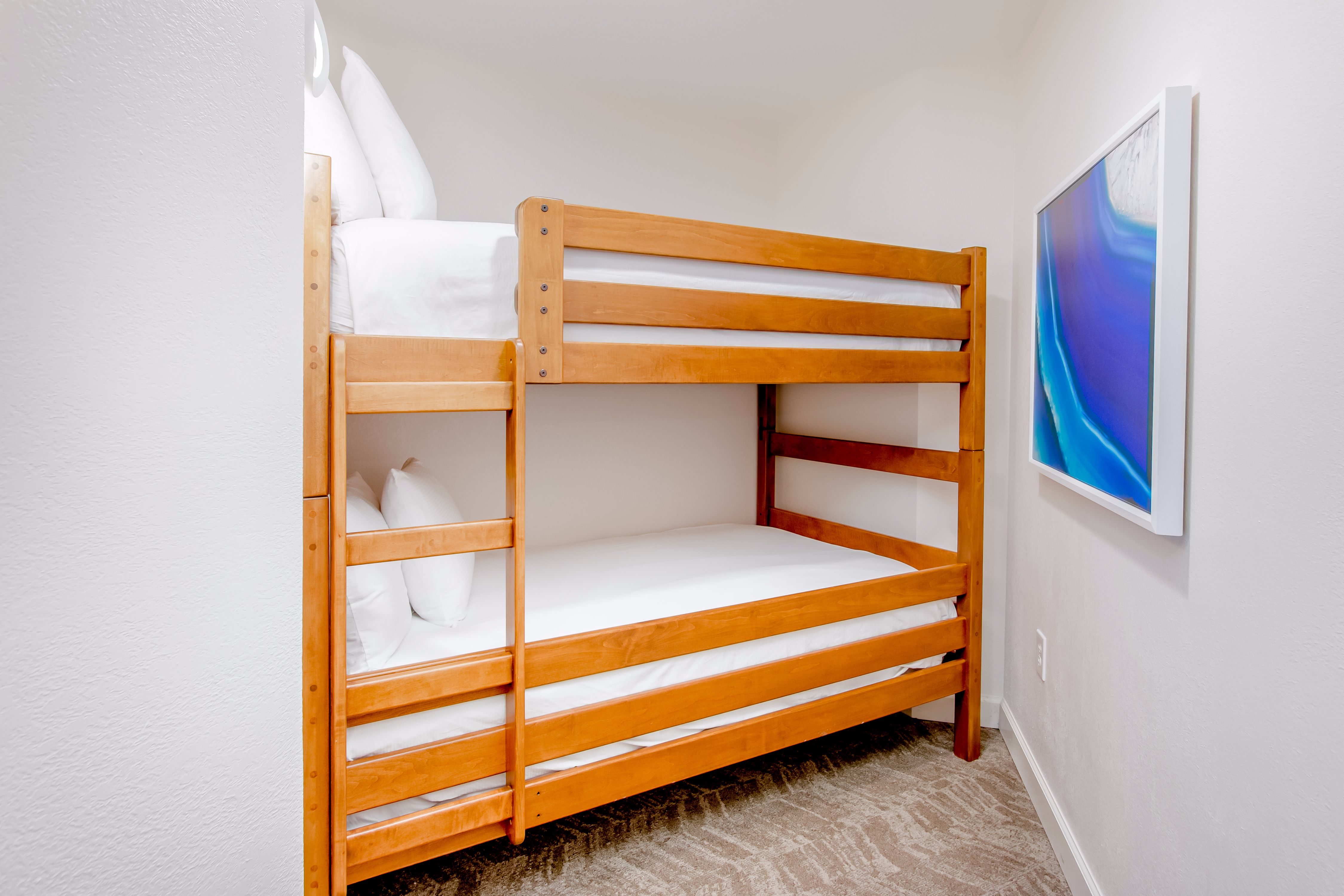 Junior suite with two queen bunk beds and art on the wall