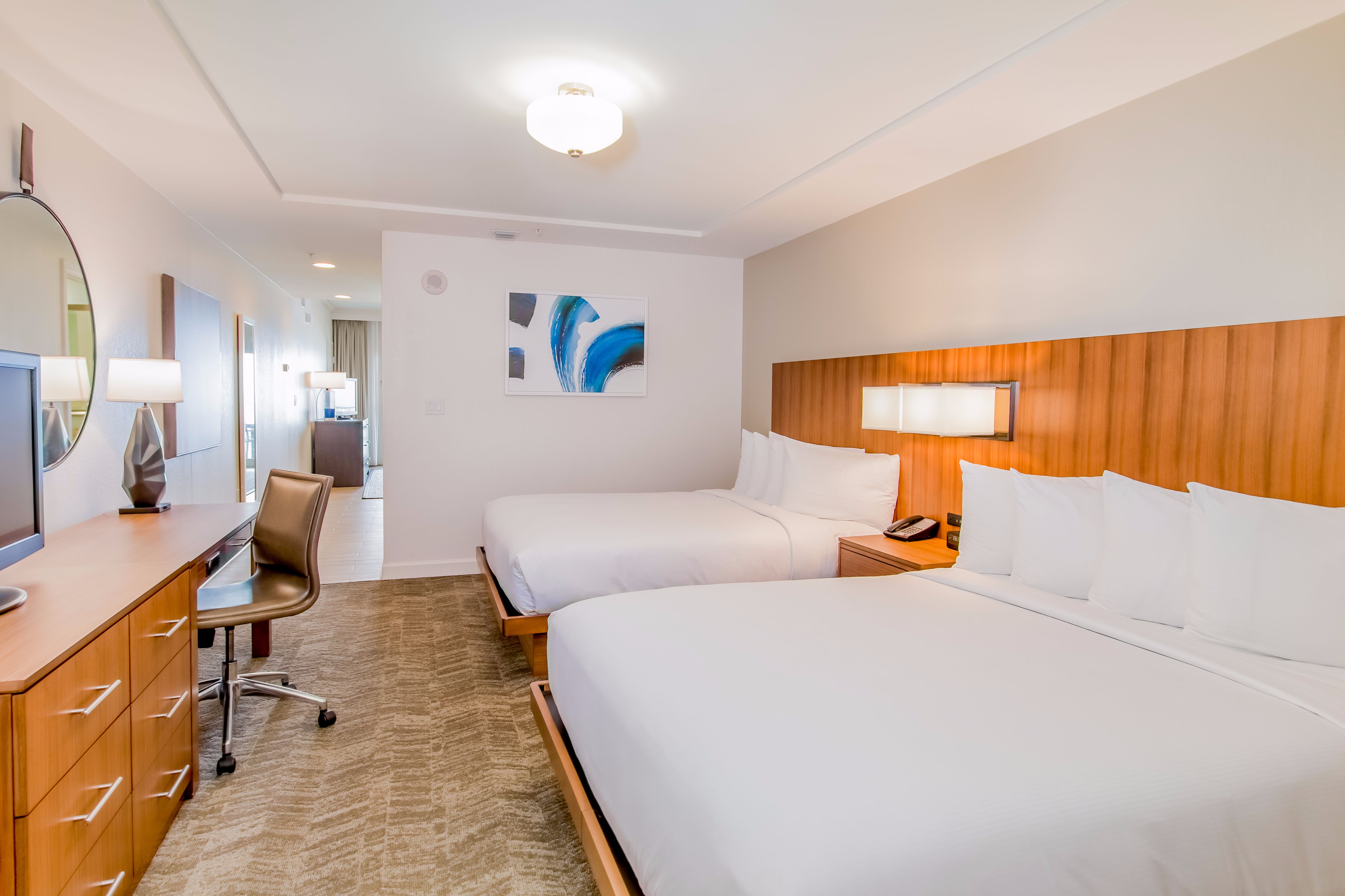 Junior suite with two queen beds, work desk, and TV