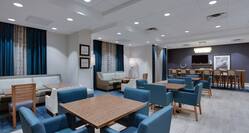 Lobby breakfast area with dining tables, chairs, and TV