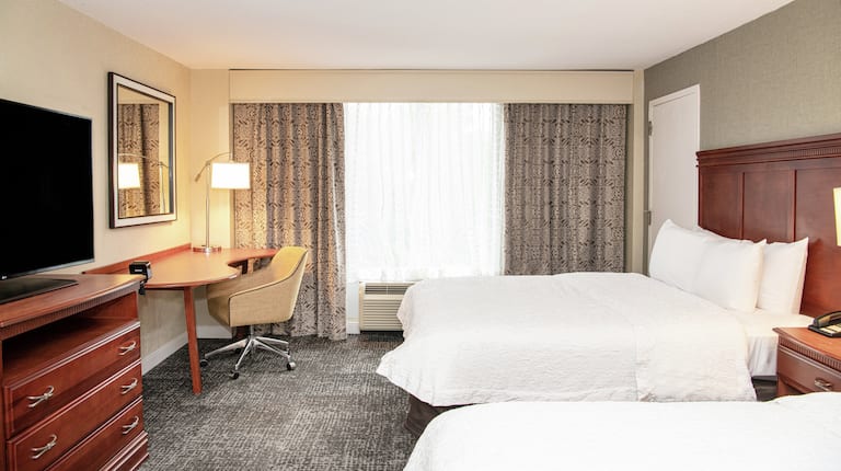 两张双人床客房,配有工作桌和电视