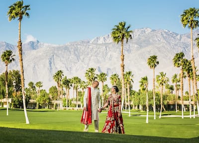 Wedding couple standing in garden in front of trees and mountains
