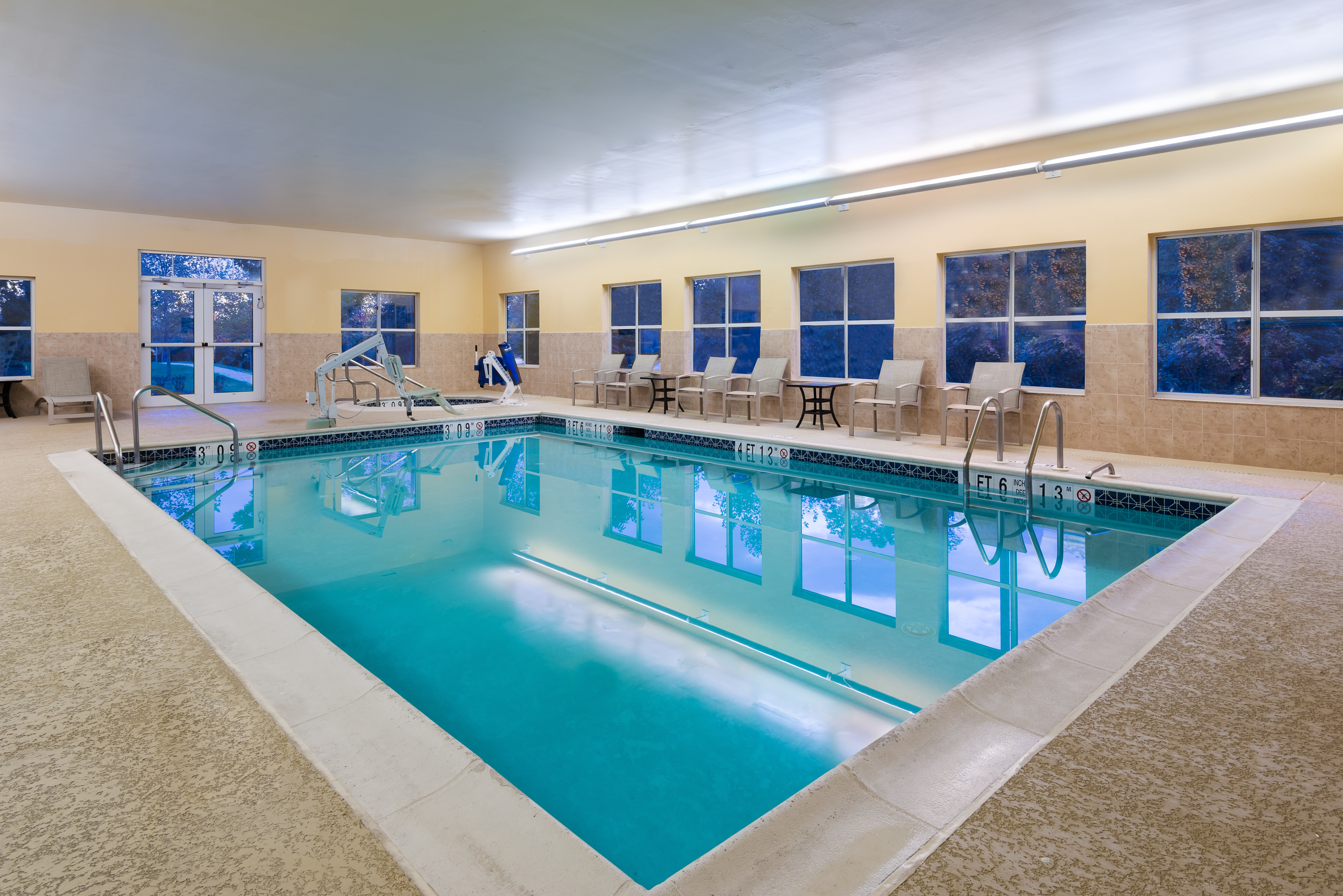 Indoor Pool with lounge chairs and room entrance